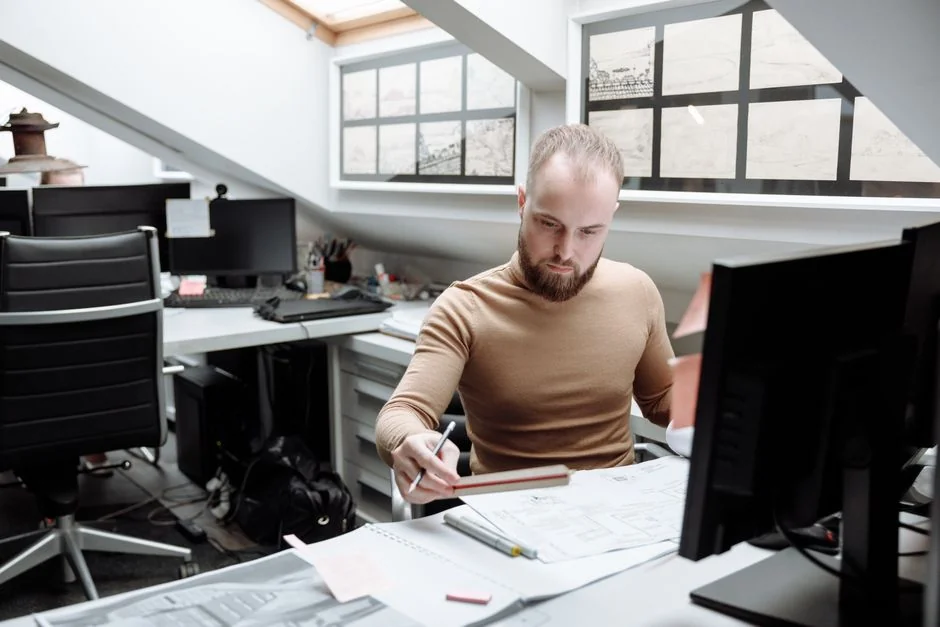 Une maquette de site web affichée sur l'écran d'un MacBook posé sur un bureau de bureau.